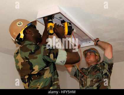 100421-N-6357K-001 ROTA, Spain (April 21, 2010) Seabees assigned to Naval Mobile Construction Battalion (NMCB) 7 hang a light fixture as part of the renovation of storage spaces at Underwater Construction Team (UCT) 1 at Naval Station Rota, Spain. NMCB-7 and its detachments are deployed to various locations throughout the U.S. 6th Fleet area of responsibility. (U.S. Navy photo by Chief Mass Communication Specialist Yan Kennon/Released) US Navy 100421-N-6357K-001 Seabees assigned to (NMCB) 7 hang a light fixture as part of the renovation of storage spaces at UCT) 1 at Naval Station Rota, Spain Stock Photo