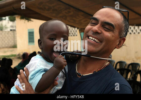 100419-M-0000T-003  NOTO GOUREY DIAME, Senegal (April 19, 2010) Cmdr. Antonio Rodriguez, senior medical officer for Africa Partnership Station (APS) West, holds a Senegalese baby during a medical outreach project. The 16-member team of U.S. Navy and Air Force medical and dental professionals have treated more than 2,000 patients in a four-day period. APS West is an international initiative developed by U.S. Naval Forces Europe-Africa that aims to improve maritime safety and security in Africa. (U.S. Marine Corps photo by 2nd Lt. Nicole P. Teat/Released) US Navy 100419-M-0000T-003 Cmdr. Antonio Stock Photo