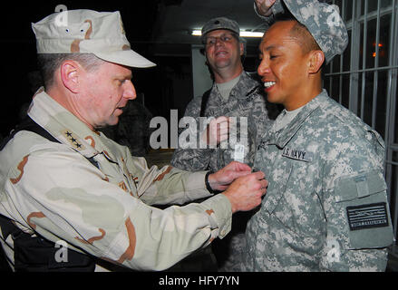 Kabul, Afghanistan - Vice Adm. Bill Gortney, left, Commander, U.S. Navy Forces Central Command/5th Fleet, tacks a “Crow” on newly frocked Petty Officer 1st Class Sydney Reyes as Cmdr. Christopher Quarles, his sponsor, replaces his cover during a frocking ceremony on Camp Eggers. During his visit to Camp Eggers, the headquarters of NATO Training Mission - Afghanistan, Gortney met with command staff, officiated at a frocking ceremony for six Sailors and spoke openly to Sailors about the importance of their mission in Afghanistan.(US Navy Photo by Chief Mass Communication Specialist F. Julian Car Stock Photo