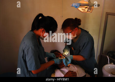 100616-N-5207L-051 SIHANOUKVILLE, Cambodia (June 16, 2010) Jennifer Tran, left, a member of the Pre-Dental Society at the University of California, San Diego, and Air Force Maj. Joanna Jaminska, both embarked aboard the Military Sealift Command hospital ship USNS Mercy (T-AH 19), extract a tooth from a Cambodian patient during a Pacific Partnership 2010 dental civic action program. Mercy is in Cambodia supporting Pacific Partnership, the fifth in a series of annual U.S. Pacific Fleet humanitarian and civic assistance endeavors, Pacific Partnership 2010 aims to strengthen regional partnerships. Stock Photo