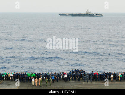 Sailors aboard the aircraft carrier USS Dwight D. Eisenhower stand at attention on the flight deck as the aircraft carrier USS Harry S. Truman transits past. The Eisenhower Carrier Strike Group is deployed as part of an ongoing rotation of forward-deployed forces supporting maritime security operations in the U.S. 5th Fleet area of responsibility. USS Dwight D. Eisenhower DVIDS294632 Stock Photo