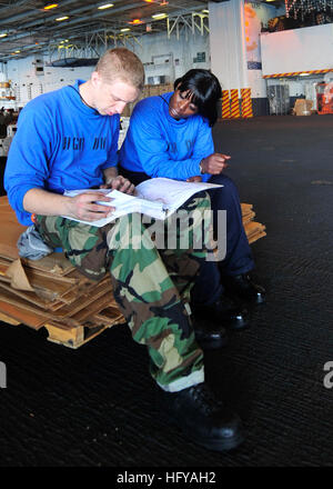 100718-N-6541W-051 ATLANTIC OCEAN (July 18, 2010) Aviation Boatswain's Mate (Handling) 3rd Class Kinia I. Guice, right, and Aviation Boatswain's Mate (Handling) Airman Chandler M. Enger study their rate training manual for the September advancement exam in the hangar bay of the aircraft carrier USS Enterprise (CVN 65). Enterprise is on a scheduled underway for fleet replacement squadron carrier qualifications and is making preparations for its 21st deployment. (U.S. Navy photo by Mass Communication Specialist 3rd Class Jared E. Walker/Released) US Navy 100718-N-6541W-051 Sailors study their ra Stock Photo