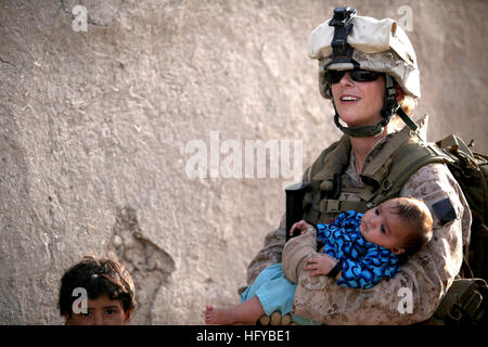 100803-M-0301S-162 HELMAND, Afghanistan (Aug. 3, 2010) Hospital Corpsman 2nd Class Claire E. Ballante, assigned to the Female Engagement Team (FET), holds a child during a patrol with 1st Battalion 2d Marines in Musa Qa'leh, Afghanistan. Ballante and fellow FET members patrol local compounds around the base. (U.S. Marine Corps photo by Cpl. Lindsay L. Sayres/Released) US Navy 100803-M-0301S-162 Hospital Corpsman 2nd Class Claire E. Ballante, assigned to the Female Engagement Team (FET), holds a child during a patrol with 1st Battalion 2d Marines Stock Photo