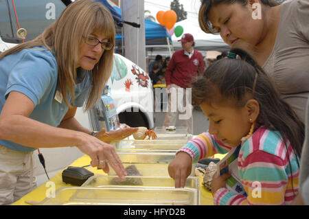 101016-N-6536T-263 LOS ANGELES, Calif. (Oct. 16, 2010) Kellie Irwin, a science instructor with the OceanÕs Institute, teaches a student how to touch sea life at a science fair during the opening of the Iridescent Science and Discovery Center. The science center is part of an outreach program with the Office of Naval Research to help engage underprivileged and urban at-risk youth. (U.S. Navy photo by Mass Communication Specialist 1st Class Elizabeth Thompson/Released) US Navy 101016-N-6536T-263 Kellie Irwin, a science instructor with the Ocean's Institute, teaches a student how to touch sea lif Stock Photo