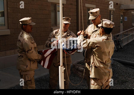 100911-N-9958G-007 CAMP ARIFJAN, Kuwait (Sept. 11, 2010) Cmdr. Marquez Campbell, left, Chief Hospital Corpsman Anthony Gourley, Cmdr. Craig Womeldorph and Senior Chief Logistics Specialist Jorge Macias prepare to raise the American flag over Expeditionary Medical Facility Kuwait (EMF-K) on Sept. 11, 2010, as part of the ninth anniversary commemoration of the terrorist attacks in New York City, Washington, D.C., and Somerset, Pa., in 2001. (U.S. Navy photo by Chief Mass Communication Specialist Bill Gowdy/Released) US Navy 100911-N-9958G-007 Cmdr. Marquez Campbell, left, Chief Hospital Corpsman Stock Photo