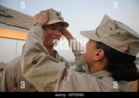 100916-N-0475R-328 HELMAND PROVINCE, Afghanistan (Sept. 16, 2010) Chief Construction Mechanic Michael Robb, left, assigned to Naval Mobile Construction Battalion (NMCB) 5, has his chiefÕs cover placed on for the first time by Chief Construction Mechanic Dawn Ayala during a chief petty officer pinning ceremony at Camp Leatherneck, Afghanistan. The Seabees of NMCB-5 are deployed to Afghanistan executing general engineering, infrastructure construction and project management supporting Operation Enduring Freedom. (U.S. Navy photo by Mass Communication Specialist 2nd Class Ace Rheaume/Released) US Stock Photo