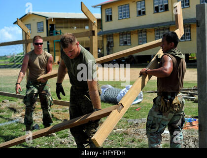 101025-N-1531D-234 NEW AMSTERDAM, Guyana (Oct. 25, 2010) Seabees assigned to Construction Maintenance Building Unit 202 of Naval Mobile Construction Battalion (NMCB) 7 and Marines from Special Purpose, Marine Air Ground Task Force, embarked aboard the multi-purpose amphibious assault ship USS Iwo Jima (LHD 7), lift a wooden fence frame outside the Corentyne School during a Continuing Promise 2010 engineering community service event. Iwo Jima is participating in the Continuing Promise 2010 humanitarian civic assistance mission. The assigned medical and engineering staff embarked aboard Iwo Jima Stock Photo