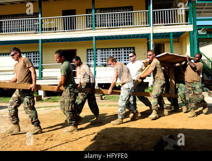 101025-N-1531D-306 NEW AMSTERDAM, Guyana (Oct. 25, 2010) Seabees assigned to Construction Maintenance Building Unit 202 of Naval Mobile Construction Battalion (NMCB) 7 and Marines from Special Purpose, Marine Air Ground Task Force, embarked aboard the multi-purpose amphibious assault ship USS Iwo Jima (LHD 7), carry a basketball hoop to the court in front of the Corentyne School during a Continuing Promise 2010 engineering service event. Iwo Jima is participating in the Continuing Promise 2010 humanitarian civic assistance mission. The assigned medical and engineering staff embarked aboard Iwo Stock Photo