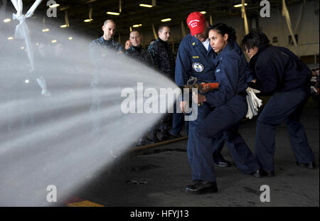 101214-N-2475A-113 PUGET SOUND (Dec. 14, 2010) Personnel Specialist 3rd Class Roanny Estevez, from New York, handles the hose during a live hose training in the hangar bay aboard the Nimitz-class aircraft carrier USS John C. Stennis (CVN 74). (U.S. Navy photo by Mass Communication Specialist 3rd Class Kenneth Abbate/Released) US Navy 101214-N-2475A-113 Personnel Specialist 3rd Class Roanny Estevez handles the hose during a live hose training in the hangar bay aboard USS Stock Photo