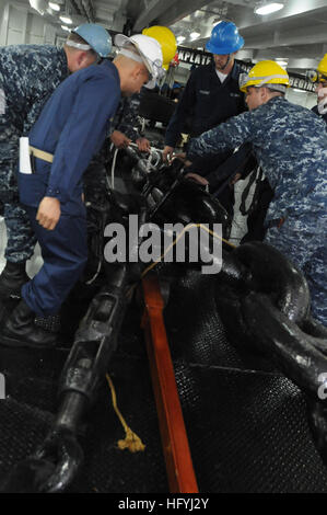 Deck Department sailors aboard the aircraft carrier USS Ronald Reagan secure the chain stoppers in the foc'sle as the ship gets underway from its home port of San Diego. Chain stoppers hold the ship's anchor in the up position when the ship is underway or moored pierside.  Sailors from Deck Department successfully completed a starboard anchor drop test shortly after getting underway to conduct operations in preparation for an upcoming deployment.  (Photo by: Petty 3rd Class Officer Oliver Cole) USS Ronald Reagan Leaves Homeport DVIDS350228 Stock Photo