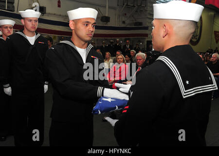 110401-N-KD852-536 SAN DIEGO (April 1, 2011) Culinary Specialist 3rd Class Phillip Cotoio passes the national ensign to Logistics Specialist 2nd Class Marcusallen Burdios during a retirement ceremony for Chief Culinary Specialist Oscar Flores aboard the multi-purpose amphibious assault ship USS Makin Island (LHD 8). Former President William Jefferson Clinton and Secretary of State Hillary Rodham Clinton attended the ceremony. Flores works for the Clinton family and previously served the president during an assignment at the White House. (U.S. Navy photo by Chief Mass Communication Specialist J Stock Photo
