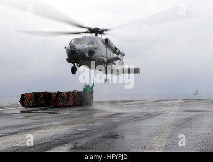 110423-N-SG869-021 PACIFIC OCEAN (April 23, 2011) Logistics Specialist 3rd John Laughlin, from Hanford, Calif., and Logistics Specialist 1st Class Kristopher Forest, from Watts, Calif., hook a load onto an SH-60H Sea Hawk helicopter assigned to the Black Knights of Helicopter Anti-Submarine Squadron (HS) 4, aboard the aircraft carrier USS Ronald Reagan (CVN 76) during a vertical replenishment. Ronald Reagan is operating in the Pacific Ocean. (U.S. Navy photo by Mass Communication Specialist 2nd Class Josh Cassatt/Released) US Navy 110423-N-SG869-021 Logistics Specialist 3rd John Laughlin, from Stock Photo