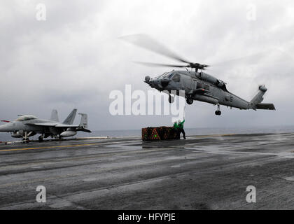 110423-N-SG869-047 PACIFIC OCEAN (April 23, 2011) Logistics Specialist Seaman Immanuel Carter, from Los Angeles, and Logistics Specialist 1st Class Kristopher Forest, from Watts, Calif., hook a load onto an SH-60H Sea Hawk helicopter assigned to the Black Knights of Helicopter Anti-Submarine Squadron (HS) 4, aboard the aircraft carrier USS Ronald Reagan (CVN 76) during a vertical replenishment. Ronald Reagan is operating in the Pacific Ocean. (U.S. Navy photo by Mass Communication Specialist 2nd Class Josh Cassatt/Released) US Navy 110423-N-SG869-047 Logistics Specialist Seaman Immanuel Carter Stock Photo