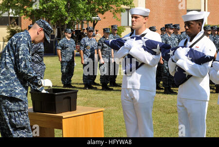 110614-N-ZZ999-029 FORT MEADE, Md. (June 14, 2011) Cryptologic Technician (Networks) 3rd Class Thomas Farquharson places a decommissioned U.S. Flag into a soaking station filled with kerosene before placing it into a fire pit during a flag decommissioning ceremony at Fort George G. Meade, Md. (U.S. Navy photo by Mass Communication Specialist 3rd Class Matthew Jordan/Released) US Navy 110614-N-ZZ999-029 Cryptologic Technician (Networks) 3rd Class Thomas Farquharson places a decommissioned U.S. Flag into a soaking station Stock Photo