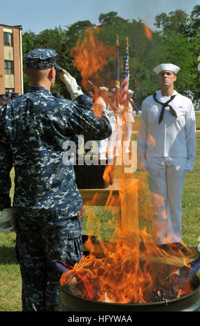 110614-N-ZZ999-062 FORT MEADE, Md. (June 14, 2011) Cryptologic Technician (Networks) 3rd Class Thomas Farquharson salutes after placing the last decommissioned U.S. Flag into a fire pit during a flag decommissioning ceremony at Navy Information Operations Command (NIOC) Maryland at Fort George G. Meade, Md. (U.S. Navy photo by Mass Communication Specialist 3rd Class Matthew Jordan/Released) US Navy 110614-N-ZZ999-062 Cryptologic Technician (Networks) 3rd Class Thomas Farquharson salutes after placing the last decommissioned U.S. Flag i Stock Photo