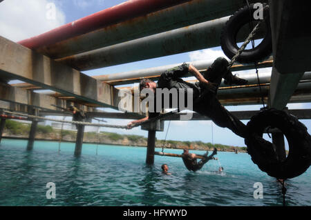 110627-N-YO394-553 CURACAO, Netherlands Antilles (June 27, 2011) Operations Specialist 2nd Class Joshua Mederos, right, assigned to Riverine Squadron (RIVRON) 3, climbs across a rope line during a water obstacle course physical training exercise with members of the Royal Netherlands Marine Corps. RIVRON-3 is cross-training with elements of the Dutch marine corps and navy for a three-week training course intended to familiarize U.S. Navy Sailors with Dutch ship-to-shore amphibious operations. (U.S. Navy photo by Mass Communication Specialist 2nd Class Paul D. Williams/Released) US Navy 110627-N Stock Photo