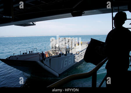 A landing craft utility enters the well deck of the amphibious assault ...