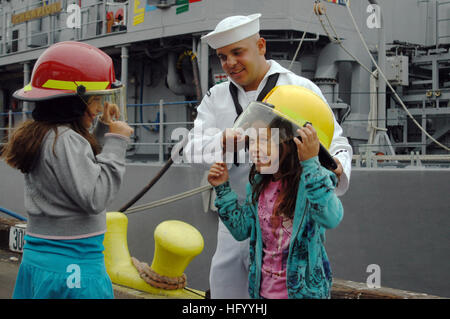 110727-N-OB313-070 LOS ANGELES (July 27, 2011) Damage Controlman 3rd Class Andrew Perez, assigned to the mine countermeasures ship USS Champion (MCM 4), helps children put on damage control helmets. Champion is participating in Los Angeles Navy Week 2011, one of 21 Navy Weeks being held this year across the country. Navy Weeks are intended to showcase the investment Americans have made in their Navy and increase awareness in cities that do not have a significant Navy presence. (U.S. Navy photo by Mass Communication Specialist 2nd Class T. J. Ortega/Released) US Navy 110727-N-OB313-070 Damage C Stock Photo