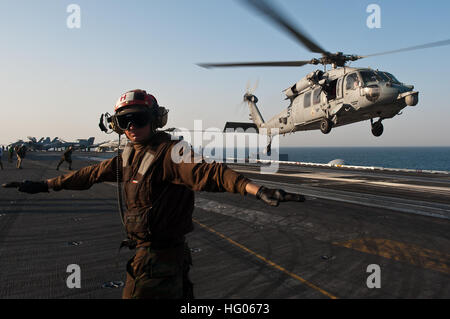 110927-N-BT887-053  ARABIAN GULF (Sept. 27, 2011) Aviation Machinist’s Mate Airman Jesse Garman checks for a clear deck as an MH-60S Sea Hawk helicopter from Helicopter Sea Combat Squadron (HSC) 8 takes off aboard the Nimitz-class aircraft carrier USS John C. Stennis (CVN 74). John C. Stennis is deployed to the U.S. 5th Fleet area of responsibility conducting maritime security operations and support missions as part of Operations Enduring Freedom and New Dawn. (U.S. Navy photo by Mass Communication Specialist 3rd Class Benjamin Crossley/Released) US Navy 110927-N-BT887-053 Aviation Machinist's Stock Photo
