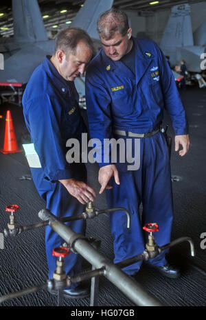 111019-N-SF704-038   GULF OF THAILAND (Oct. 19, 2011) Cmdr. Gustavo Vergara, chief engineer aboard the aircraft carrier USS George Washington (CVN 73), left, and Senior Chief Hull Maintenance Technician Sheridan Baldwin from Dallas, Ga., inspect a potable water rig prior to testing. George Washington is conducting a patrol in the western Pacific region.(U.S. Navy photo by Mass Communication Specialist 2nd Class William Pittman/Released) US Navy 111019-N-SF704-038 Cmdr. Gustavo Vergara, chief engineer aboard the aircraft carrier USS George Washington (CVN 73), left, and Senior Chief Stock Photo