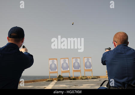 111022-N-XQ375-547 ARABIAN GULF (Oct. 22, 2011) Operations Specialist 3rd Class Dustin Reeves, left, and Lt. j.g. Jason Coyle fire 9mm pistols during a weapons qualification aboard the guided-missile destroyer USS Mitscher (DDG 57). Mitscher is deployed to the U.S. 5th Fleet area of responsibility conducting maritime security operations and theater support cooperation efforts. (U.S. Navy photo by Mass Communication Specialist 3rd Class Deven B. King/Released) US Navy 111022-N-XQ375-547 Operations Specialist 3rd Class Dustin Reeves, left, and Lt. j.g. Jason Coyle fire 9mm pistols during a weapo Stock Photo