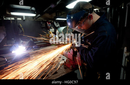 120107-N-OY799-055  ARABIAN SEA (Jan. 07, 2012) Hull Maintenance Technician Fireman Apprentice Mitchell Myrstol, left, welds a bracket while Hull Maintenance Technician Fireman Tom Fields grinds a rod in the sheet metal shop aboard the Nimitz-class aircraft carrier USS John C. Stennis (CVN 74). John C. Stennis is deployed to the U.S. 5th Fleet area of responsibility conducting maritime security operations and support missions as part of Operation Enduring Freedom. (U.S. Navy photo by Mass Communication Specialist 3rd Class Kenneth Abbate/Released) US Navy 120107-N-OY799-055 Hull Maintenance Te Stock Photo