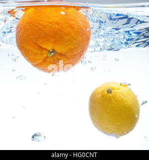 Lemon and orange floating in the water on a white background Stock Photo
