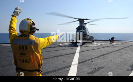 120201-N-LP801-567 PACIFIC OCEAN (Feb 1, 2012) Boatswain’s Mate 2nd Class Caesar Castro directs a CH-46 Sea Knight helicopter during flight operations aboard the forward-deployed amphibious dock landing ship USS Germantown (LSD 42). Germantown is part of the Essex Amphibious Ready Group and is conducting operations in the western Pacific region. (U.S. Navy photo by Mass Communication Specialist Seaman Raul Moreno Jr./Released) US Navy 120201-N-LP801-567 Boatswain's Mate 2nd Class Caesar Castro directs a CH-46 Sea Knight helicopter during flight operations aboard the forwa Stock Photo