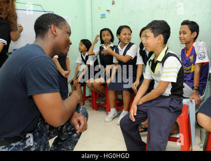 130604-N-YF014-032 KUALA LUMPUR, Malaysia (June 4, 2013) --  Seaman Robert Thomas, assigned to U.S. 7th Fleet flagship USS Blue Ridge (LCC 19), interacts with children at the Lautu Refugee Learning Centre in Kuala Lumpur, Malaysia. Blue Ridge port visits represent an opportunity to promote peace and stability in the South Indo-Asia Pacific region, demonstrate commitment to regional partners and foster growing relationships. (U.S. Navy photo by Mass Communication Specialist 3rd Class Ben Larscheid/Released) USS Blue Ridge activity 130604-N-YF014-032 Stock Photo