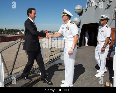 From left, Adam H. Sterling, the Charge d?Affaires at the U.S. Embassy in Amsterdam, shakes hands with U.S. Navy Cmdr. Wilson Marks, the commanding officer of the guided missile destroyer USS Mason (DDG 87), as Lt. Cmdr. Mikal Phillips, the ship?s executive officer, stands by Aug. 5, 2013, in Amsterdam. The Mason was on a port visit to the city while deployed as part of the Harry S. Truman Carrier Strike Group in support of maritime security operations and theater security cooperation efforts in the U.S. 6th Fleet area of responsibility. (U.S. Navy photo by Mass Communication Specialist 2nd Cl Stock Photo