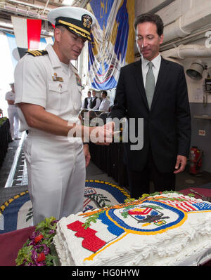 U.S. Navy Cmdr. Wilson Marks, left, the commanding officer of the guided missile destroyer USS Mason (DDG 87), and Adam H. Sterling, the Charge d?Affaires at the U.S. Embassy in Amsterdam, prepare to cut a cake during a reception aboard the ship Aug. 5, 2013, in Amsterdam. The Mason was on a port visit to the city while deployed as part of the Harry S. Truman Carrier Strike Group in support of maritime security operations and theater security cooperation efforts in the U.S. 6th Fleet area of responsibility. (U.S. Navy photo by Mass Communication Specialist 2nd Class Rob Aylward/Released) USS M Stock Photo