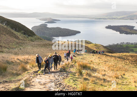 Conic Hill, Balmaha, Loch Lomond, Scotland. 2 January 2017. UK weather: Families enjoying a bright morning walk up Conic Hill - a popular, but unusually busy summit rising above the village of Balmaha.  The short hill walk which forms part of the West Highland Way lies right on the Highland Boundary Fault, and rewards walkers with fantastic views over Loch Lomond. Credit: Kay Roxby/Alamy Live News Stock Photo