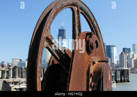 A view of the Freedom Tower under construction in March of 2012.  The tower is viewed through an old rusty ferry wheel at Liberty State Park. Stock Photo