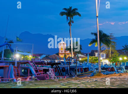 Brazil, State of Rio de Janeiro, Paraty, Twilight view of the port and the Santa Rita Church. Stock Photo
