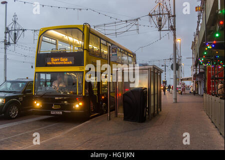 A Blackpool Transport bus stops on the promenade in Blackpool to pick up passengers heading to Starr Gate. Stock Photo