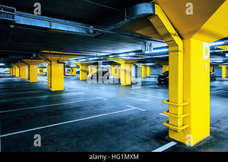 Underground garage parking lot with few cars and empty spaces for more vehicles, urban exploration and geometry in architecture Stock Photo