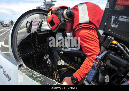 Aviation Ordnanceman Airman Corey Langsdorf, a Winfield, W.V., native assigned to the 'Gauntlets' of Electronic Attack Squadron (VAQ) 136, inspects an aircraft cockpit before a flight, aboard the aircraft carrier USS Ronald Reagan (CVN 76). Ronald Reagan is participating in Rim of the Pacific (RIMPAC) 2014. Twenty-two nations, more than 40 ships and submarines, more than 200 aircraft and 25,000 personnel are participating in RIMPAC exercise from June 26 to Aug. 1, in and around the Hawaiian Islands. The world's largest international maritime exercise, RIMPAC provides a unique training opportun Stock Photo