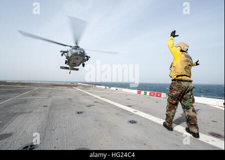 150210-N-XG464-092  ARABIAN GULF (Feb. 10, 2015) - Aviation Support Equipment Technician 2nd Class Adam Haffner, a Monroeville, Ind., native stationed aboard amphibious transport dock ship USS New York (LPD 21), directs the takeoff of an MH-60S Sea Hawk assigned to Helicopter Sea Combat Squadron (HSC) 26 during flight operations Feb. 10, 2015. New York is a part of the Iwo Jima Amphibious Ready Group (ARG) and, with the embarked 24th Marine Expeditionary Unit (MEU), is deployed in support of maritime security operations and theater security cooperation efforts in the U.S. 5th Fleet area of ope Stock Photo