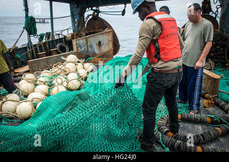 150219-N-JP249-077 ATLANTIC OCEAN (Feb. 19, 2015) A Ghanaian police officer, working in conjunction with the Military Sealift Command’s joint high-speed vessel USNS Spearhead (JHSV 1), inspects the fishing nets aboard a fishing vessel, while conducting Africa Maritime Law Enforcement Partnership operations Feb. 19, 2015. Spearhead is on a scheduled deployment to the U.S. 6th Fleet area of operations in support of the international collaborative capacity-building program Africa Partnership Station. (U.S. Navy photo by Mass Communication Specialist 2nd Class Kenan O’Connor/Released) USNS Spearhe Stock Photo