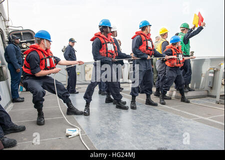 150222-N-XG464-079  ARABIAN GULF (Feb. 22, 2015) - Sailors stationed aboard the amphibious transport dock ship USS New York (LPD 21) heave the distance line during an underway replenishment-at-sea with the Military Sealift Command fleet replenishment oiler USS Walter S. Diehl (T-AO 193) and the amphibious dock landing ship USS Fort McHenry (LSD 43) Feb. 22, 2015. New York is a part of the Iwo Jima Amphibious Ready Group (ARG) and, with the embarked 24th Marine Expeditionary Unit (MEU), is deployed in support of maritime security operations and theater security cooperation efforts in the U.S. 5 Stock Photo