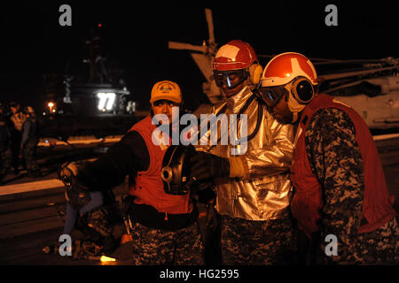 150310-N-VH385-077  NORFOLK (March 10, 2015) – Sailors aboard the Nimitz-class aircraft carrier USS Theodore Roosevelt (CVN 71) participate in a flight deck drill. TR holds flight deck drills to train Sailors on proper procedures during emergency situations. TR and its Sailors will conduct operations in the 5th, 6th and 7th Fleet areas of responsibility supporting maritime security operations in international waters around the world. (U.S. Navy Photo by Mass Communication Specialist Seaman Wyatt L. Anthony/Released) USS Theodore Roosevelt operations 150310-N-VH385-077 Stock Photo