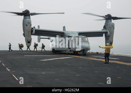 150331-N-RU971-061 WATERS TO THE EAST OF THE KOREAN PENINSULA (March 31, 2015) – An MV-22 Osprey tiltrotor aircraft offloads Marines assigned to the 31st Marine Expeditionary Unit (MEU) returning from the Korean Marine Exchange Program (KMEP) on the flight deck of the forward-deployed amphibious assault ship USS Bonhomme Richard (LHD 6). U.S. Sailors and Marines from the Bonhomme Richard Amphibious Ready Group (ARG) and the 31st MEU are participating in the KMEP in the Republic of Korea (ROK) with the ROK marine corps and navy. The Bonhomme Richard ARG is comprised of the amphibious assault sh Stock Photo