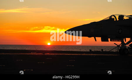 The sun rises over the flight deck before a full-bore, full metal jacket drill onboard the nuclear aircraft carrier USS George Washington. USS George Washington is currently participating in Exercise Talisman Sabre 2011. Talisman Sabre is a bilateral exercise designed to train Australian and U.S. forces in planning and conducting combined task force operations in order to improve Australian and U.S. combat readiness and interoperability. (Photo by: Petty Officer 3rd Class Marcus D. Mince) US sailors participate in Talisman Sabre 2011 110722-N-MH885-023 Stock Photo