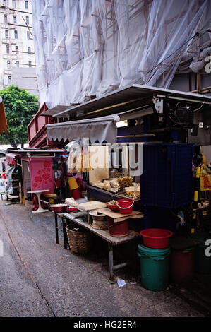 Hong Kong building with bamboo scaffolding and market stand Stock Photo