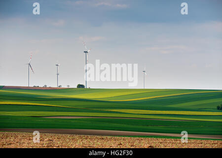 Green environment. Eco power. Wind turbines generating electricity. Spring sunny day on green field with wind power generators in Austria Stock Photo