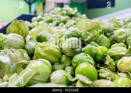 Background pile of fresh organic green tomatillos with husks. Stock Photo