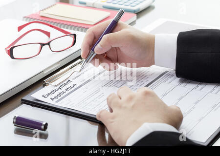 Businessman or job seeker fill in Employment Application form with pen. job vacancy concept. Stock Photo