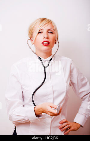 funny doctor with stethoscope, smiling blond woman medical equipment showing on white background Stock Photo