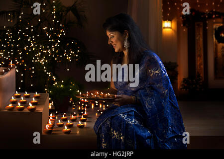 Woman arranging oil lamps at a diwali festival Stock Photo