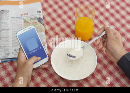 Man using Cell phone while having breakfast Stock Photo